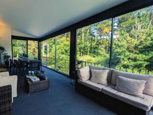 ein Wohnzimmer mit einem Sofa und großen Fenstern in der Unterkunft Casas de Pedra in Camacha