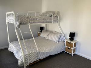 een slaapkamer met een stapelbed en een nachtkastje bij Fairlight House in Culburra Beach