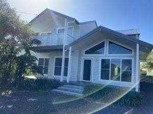 een wit huis met een groot raam bij Fairlight House in Culburra Beach