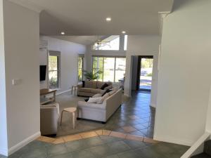 een woonkamer met een bank en een tafel bij Fairlight House in Culburra Beach
