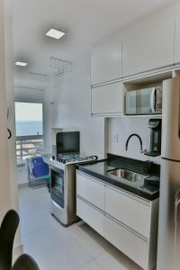 イタパリカにある2Q moderno c/ Piscina e Academiaのシンクとコンロのある白いキッチン