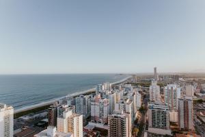 イタパリカにある2Q moderno c/ Piscina e Academiaの都市と海の空中写真