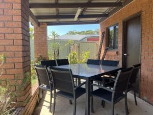 a black table and chairs on a patio at Magnolia in Culburra Beach