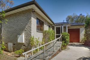 een stenen huis met een trap naar een garage bij Seabreeze Arches in Callala Bay