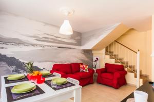 a living room with two red chairs and a table at Pueblito in Corralejo