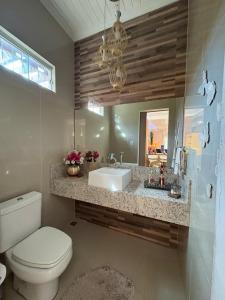 a bathroom with a sink and a toilet and a mirror at Aconchego de luxo para COP 30 in Castanhal +24 photos