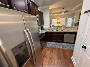 サンタ・ローザ・ビーチにあるSanta Rosa Beach Simple and Peaceful Livingのステンレス製の冷蔵庫と木製の床を備えたキッチン