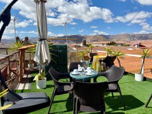 un patio avec une table et des chaises sur l'herbe dans l'établissement Hotel Plateros, à Cusco