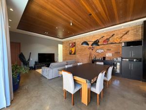 a kitchen and living room with a table and chairs at Oka Tupis - casa de luxo para executivos c sauna e piscina aquecida in Santa Bárbara dʼOeste