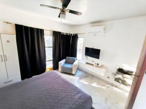 a bedroom with a bed and a tv and a chair at Alojamientos La Martina in Colón