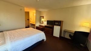 a hotel room with a bed and a television at clarion hometown inn in Clarion