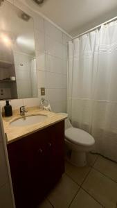 a bathroom with a sink and a toilet and a mirror at A pasos del estadio Mundial Sub20 Talca in Talca