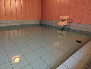 a bathroom with a tiled floor with a light on it at RYOKAN優勝館Hotel in Osaka