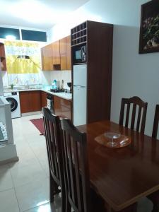 a kitchen with a wooden table and a dining room at Repousando in Mão para Trás