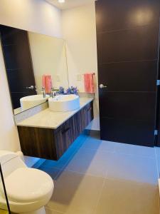 une salle de bain avec un lavabo, des toilettes et un miroir dans l'établissement Acacia Resort, Nuevo Vallarta, à Nuevo Vallarta