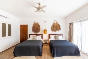 a bedroom with two beds and a ceiling fan at 18-Bed 9BD Hotel Villa - Pool & Kitchen - Full Concierge in Tulum