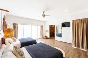 a hotel room with two beds and a couch at 18-Bed 9BD Hotel Villa - Pool & Kitchen - Full Concierge in Tulum +81 photos