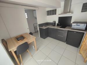 a small kitchen with a table and a counter top at Studio XL 4 places in Ducos
