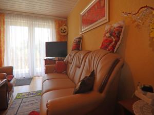 a living room with a couch and a tv at Ferienbungalow Mühlenblick in Kröpelin in Kröpelin