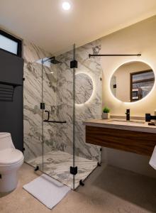 a bathroom with a shower and a toilet and a sink at The Sands Boutique Condos in Playa del Carmen
