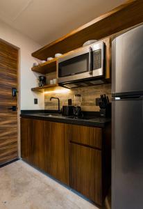 a kitchen with a stainless steel refrigerator and a microwave at The Sands Boutique Condos in Playa del Carmen