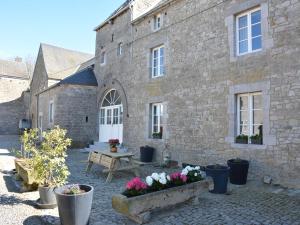 a stone building with a courtyard with potted plants at Charming Farmhouse in Ouffet for 7 in Ouffet