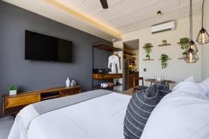 a bedroom with a bed and a flat screen tv at The Sands Boutique Condos in Playa del Carmen +32 photos