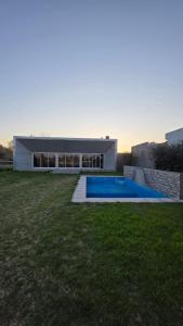 a house with a swimming pool in front of a yard at Casa Quinta en Villa Nueva Córdoba in Villa Nueva