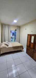 a bedroom with a bed and a dresser at Linda Casa 3 suítes in Belém