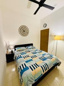 a bedroom with a bed and a ceiling fan at 122 Segari in Lumut