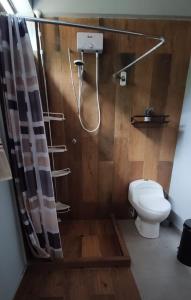 a bathroom with a shower with a toilet and a shower curtain at Casa familiar en Oxapampa hasta 5 personas con cochera in Oxapampa