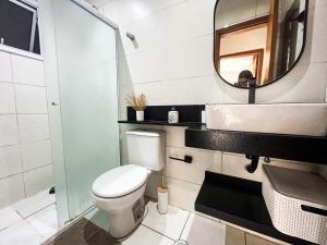 a bathroom with a toilet and a mirror at Onda76 Ap temporada Praia Grande Beira Mar churrasqueira carvão in Praia Grande +64 photos