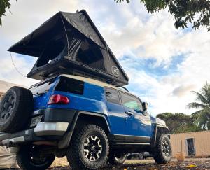 Una camioneta azul con el capó levantado en Island Rooftop Camper, en Anahola