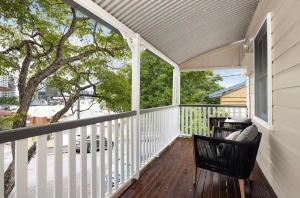 une terrasse couverte avec une chaise et un arbre dans l'établissement Historic CBD Miner's Cottage, à Brisbane