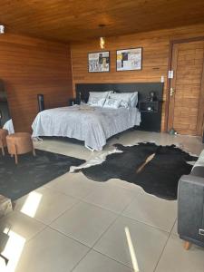 a bedroom with a bed with a large rug on the floor at Cabana Canyon in Barracão