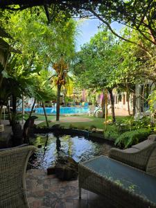 a pond in a yard with trees and a pool at OASIS Phuket Airport in Nai Yang Beach