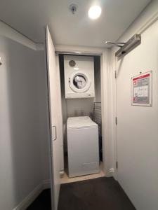 a laundry room with a washer and a washing machine at Citylife getaway Pool Gym SKB in Auckland +3 photos