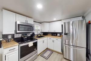 a kitchen with white cabinets and a stainless steel refrigerator at Parrot Bay 35 in Ocean City