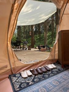 a tent with a deck in the woods at Render Fika Sammu in Sanmu