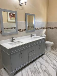 a bathroom with two sinks and a toilet at Tropical Palm Townhouse in Nassau