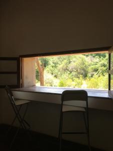 a window in a room with a chair and a table at Forest Gate Sigiriya Villa in Sigiriya +24 photos