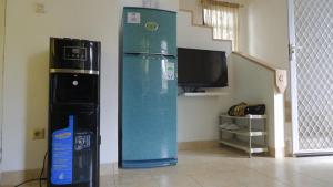 a blue refrigerator in a room with a tv at Villa Dalia Puncak NA4-11 in Cianjur