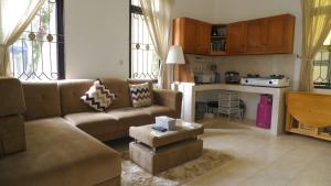a living room with a couch and a kitchen at Villa Dalia Puncak NA4-11 in Cianjur