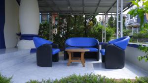 a patio with blue chairs and a table at Villa Dalia Puncak NA4-11 in Cianjur
