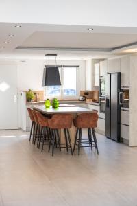 una cucina con isola, sgabelli da bar e frigorifero di Villa moderne et spacieuse Disneyland Paris a Bailly-Romainvilliers