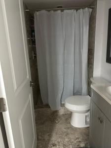 ノックスビルにあるStylish Knoxville Stay Minutes from Neyland Stdmのバスルーム(トイレ、白いシャワーカーテン付)