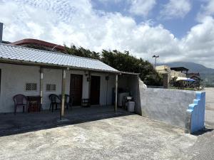 una casa con un patio con mesa y sillas en 比西里岸家屋b&b, en Chenggong