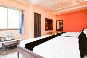 Un dormitorio con una cama grande con una pared naranja. en Hotel O Mrinmoyi Guest House, en Kulti
