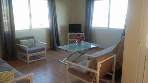 a living room with a glass table and two chairs at Maison Zita in Venda do Atalhinho