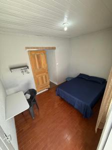 a bedroom with a bed and a table and a door at Brisa Suítes in Rio Verde